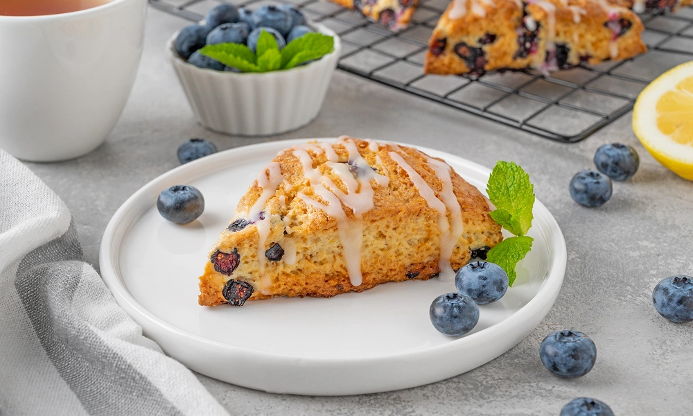 Blueberry scone with icing on plate
